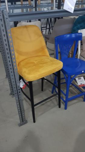 כסא בר רגלי עץ בצבע צהוב באולם התצוגה 